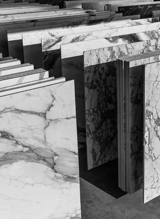 Dalles de pierre et marbre disposées en showroom illustrant une sélection de matériaux haut de gamme pour projets architecturaux