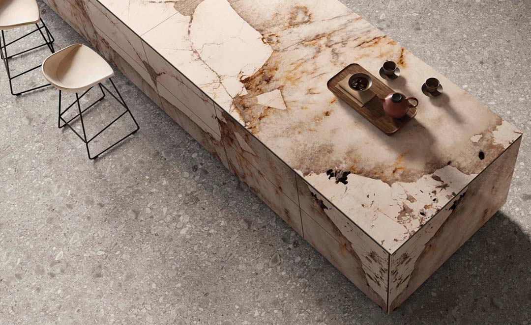 Îlot de cuisine en dalle céramique grand format effet pierre naturelle Dalle céramique XXL effet pierre naturelle utilisée en îlot de cuisine contemporain avec veinage minéral et surface texturée élégante