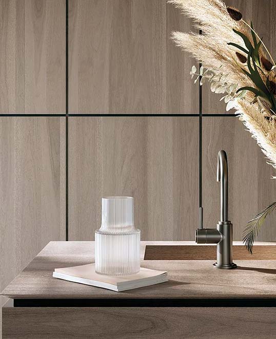 Effet bois XXL pour une atmosphère chaleureuse et contemporaine Dalles céramiques XXL effet bois habillant un mur intérieur avec texture naturelle et ambiance chaleureuse contemporaine