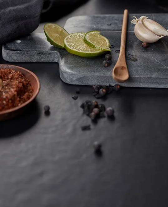 Effet résine XXL pour surfaces contemporaines sobres et élégantes Dalles céramiques XXL effet résine sur plan de travail sombre avec surface mate continue et esthétique contemporaine épurée