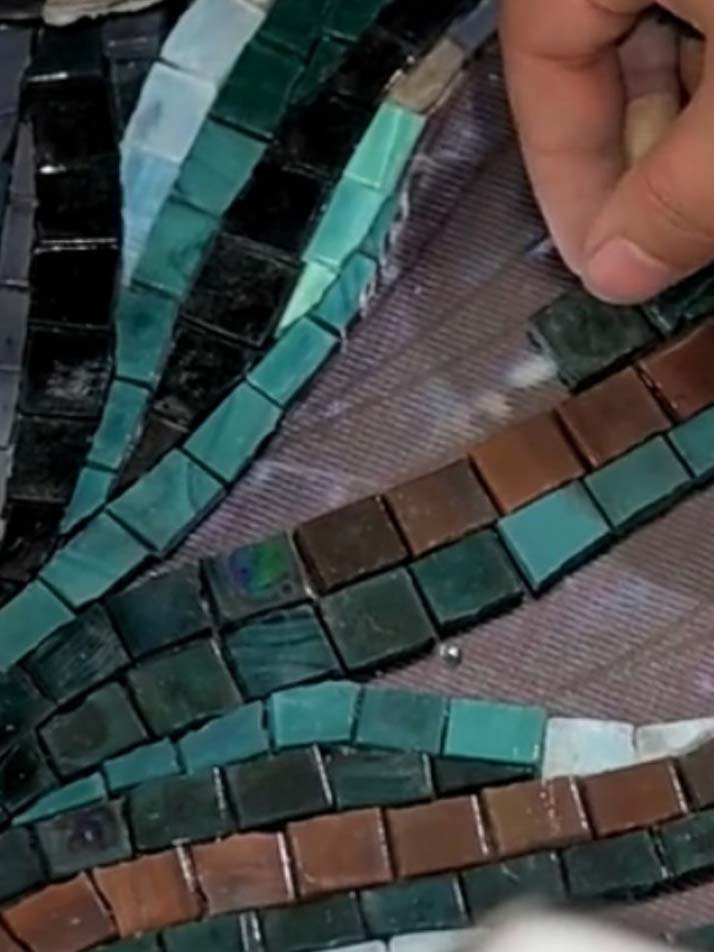 Pose manuelle de tesselles de mosaïque sur mesure illustrant la précision artisanale et la liberté de création décorative