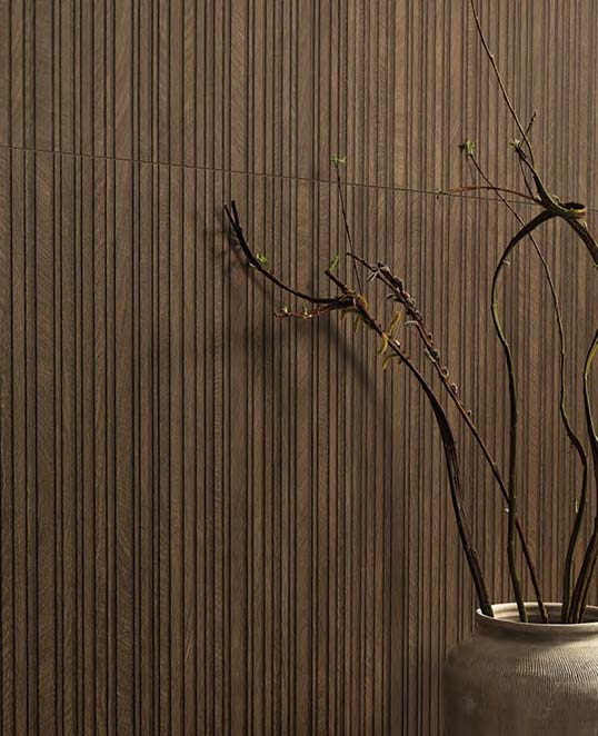 Décor 3D Slats en céramique effet bois Revêtement mural en céramique effet bois avec décor 3D Slats à relief vertical créant un jeu d’ombre et de lumière