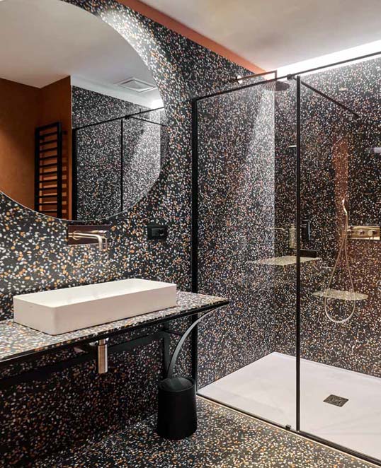 Dalles céramiques XXL effet métal autour d’une cheminée contemporaine avec texture oxydée et ambiance architecturale chaleureuse